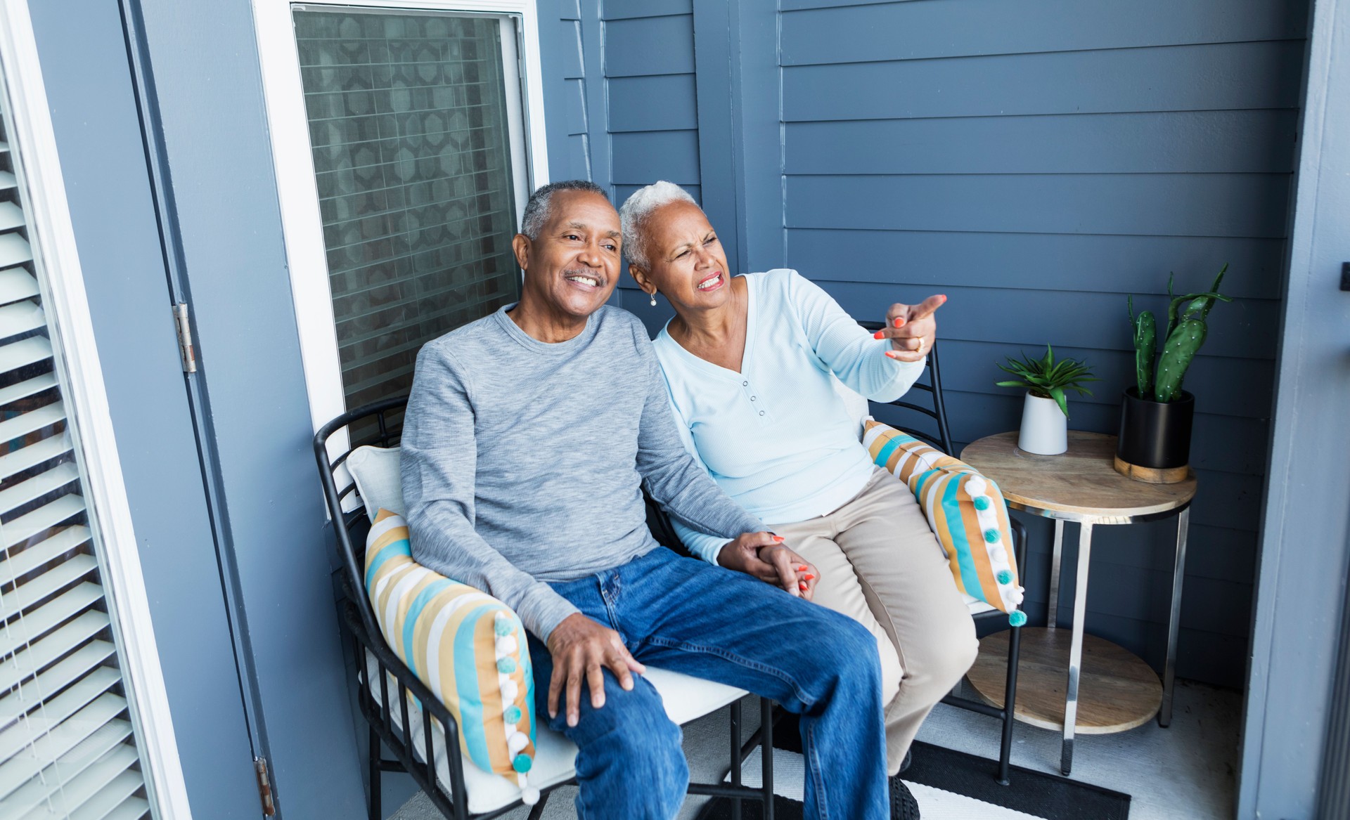 Senior couple relaxing on balcony, holding hands